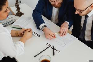 A group of people signing a contract