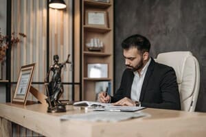 Businessman writing on paper in office