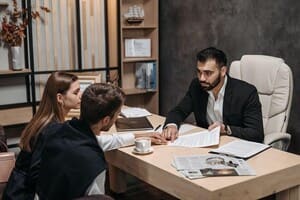 Man and woman in business attire discussing at desk