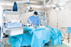 A doctor performing surgery in a room