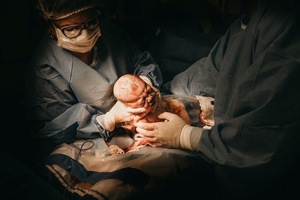 A doctor holding a baby