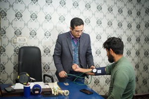 A person measuring a person's blood pressure