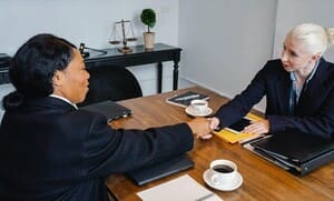Two professionals shaking hands at a table
